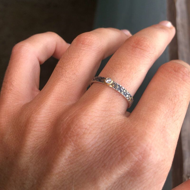 anillo apilable de diamante oro y plata en mano
